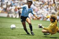 Ein brutaler Tritt ist auch beim deutschen Torwart Toni Schumacher (rechts, gegen Antonio Alzamendi) das erste, an das viele Fußballfans denken. Im WM-Halbfinale 1982 eilte der Torwart aus seinem Kasten, streckte den Franzosen Patrick Battiston nieder - und sah nicht einmal die gelbe Karte. Eine Platzwunde, ein Halswirbelbruch und drei verlorene Zähne standen am Ende des wohl brutalsten Foul der WM-Geschichte. (Bild: Getty Images / Mike King)