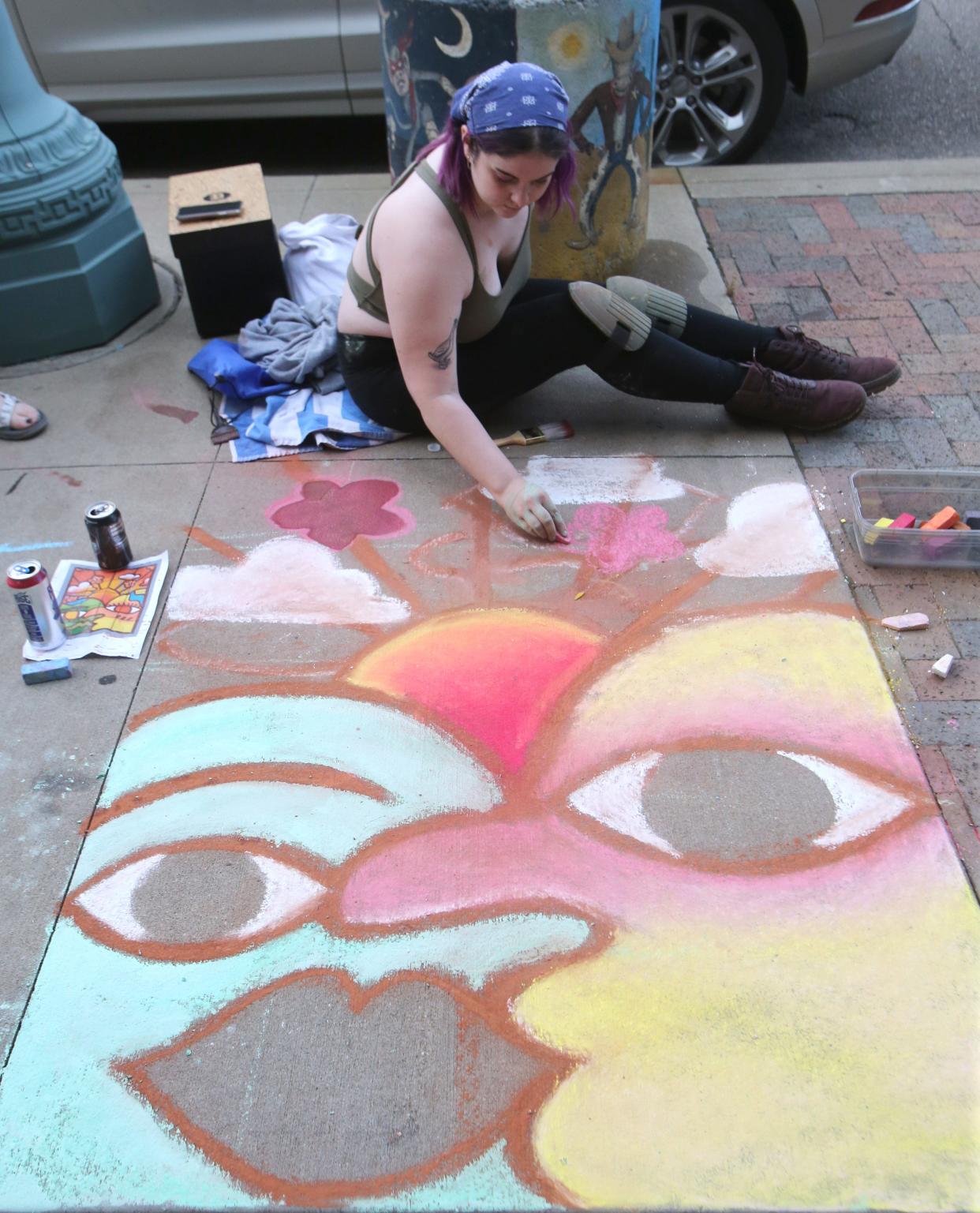 Sara Severs works on her chalk drawing during First Friday in Canton on Friday, July 2, 2021. The theme for the July 2022 First Friday is "Chalk the Walk."