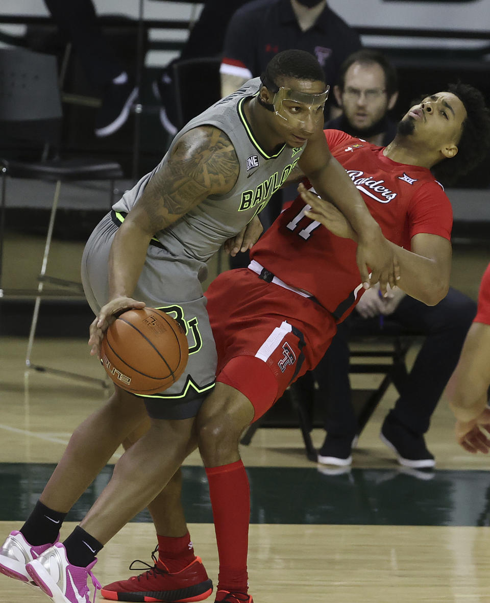 Baylor guard Mark Vital (11) drives the ball past Texas Tech guard Kyler Edwards (11) in the first half of an NCAA college basketball game Sunday, March 7, 2021, in Waco, Texas. (AP Photo/Jerry Larson)