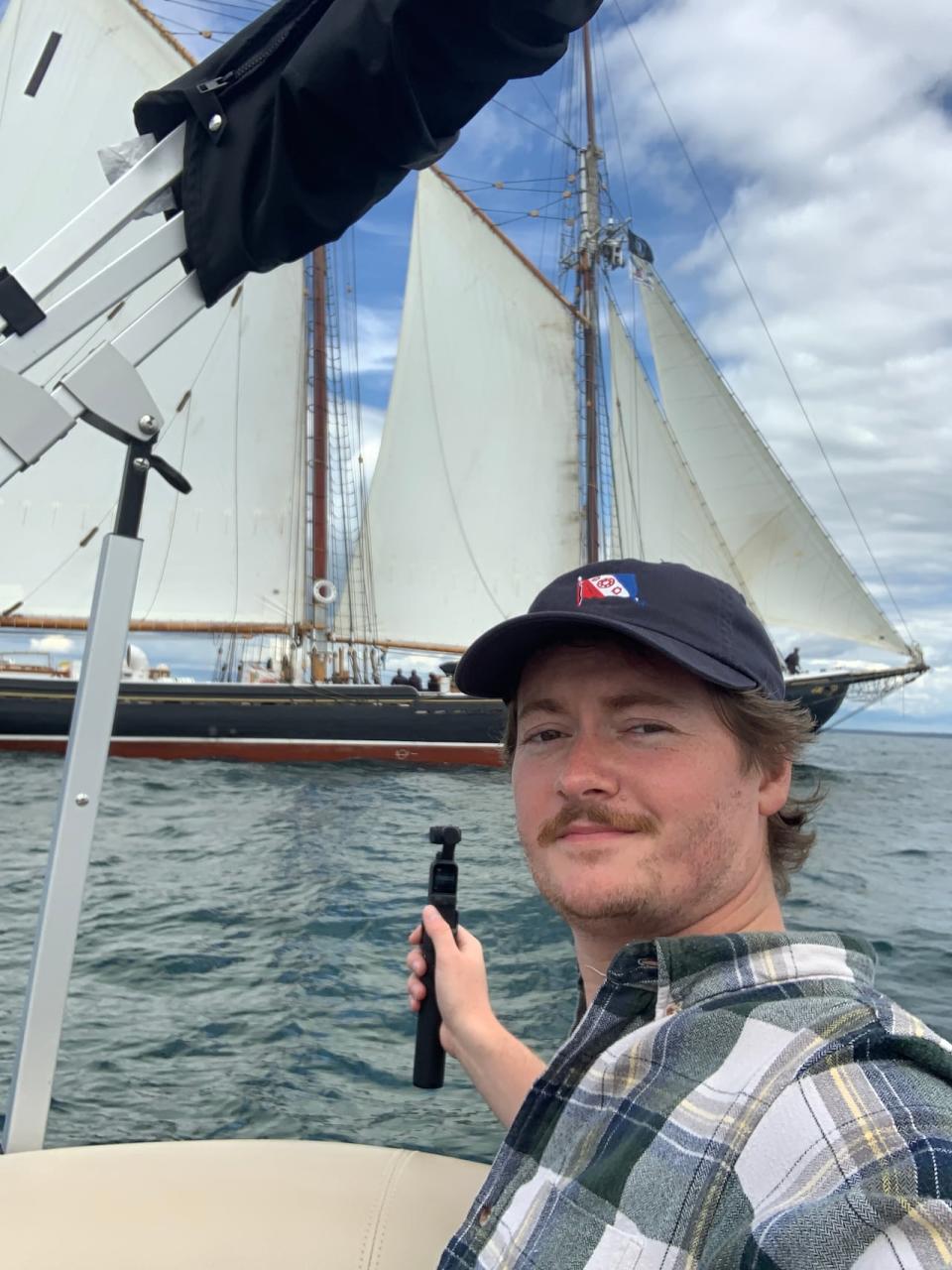 Tom Lynskey board a motor boat filming the Bluenose II