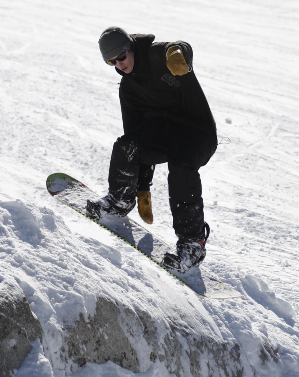 This Nov. 13, 2012 photo shows a snowboarder making a jump at Brighton Ski Resort during the first day of the ski season in the Wasatch Range, in Utah. The Brighton Ski Resort is in middle of the Wasatch Range's 7 resorts. If the resorts were to be combined, the Utah resorts could offer North America's largest skiing complex _ three times the size of Vail and twice as big as Whistler Blackcomb in British Columbia. (AP Photo/Rick Bowmer)