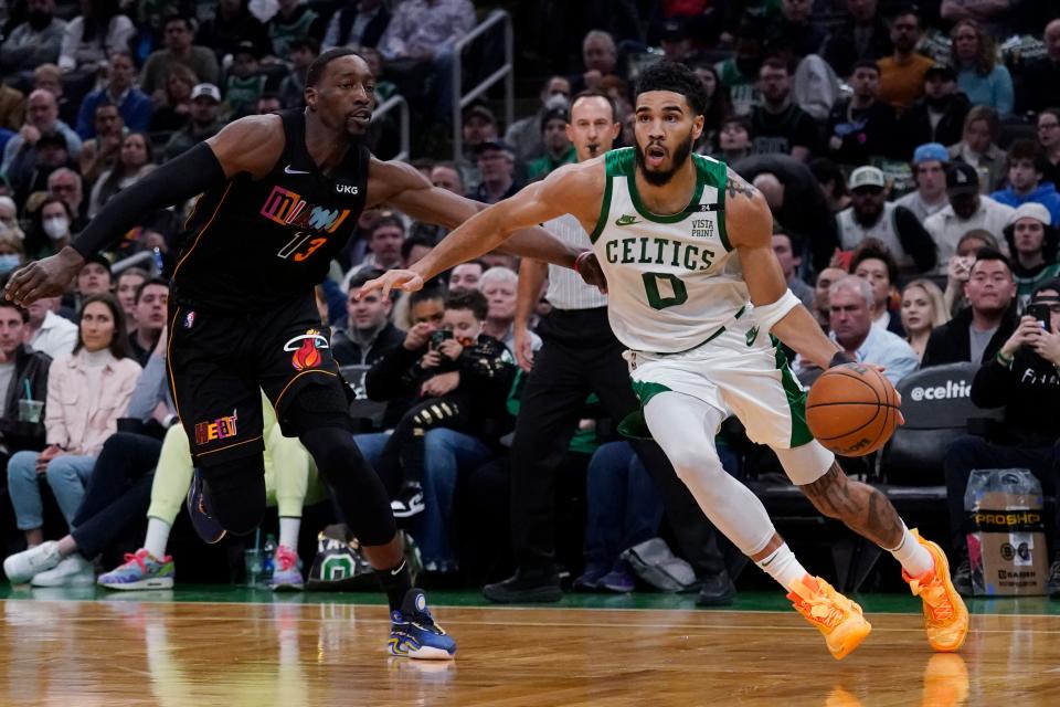 Boston Celtics forward Jayson Tatum (0) drives to the basket against Miami Heat center Bam Adebayo (13) during the first half of an NBA basketball game, Wednesday, March 30, 2022, in Boston.