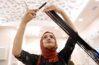 Huda Quhshi, owner and cosmetologist at the Le'Jemalik Salon and Boutique, cuts the hair of a Muslim woman ahead of the Eid al-Fitr Islamic holiday in Brooklyn, New York, U.S., June 21, 2017. Picture taken on June 21, 2017. REUTERS/Gabriela Bhaskar