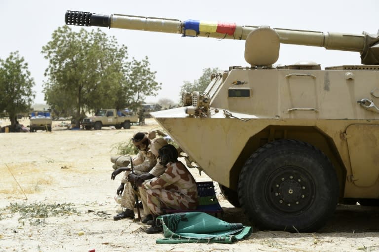 Chadian soldiers rest in the shade of their armoured vehicle near Malam Fatori in northeast Nigeria on April 3, 2015, after the town in was retaken from Boko Haram by troops from Chad and Niger