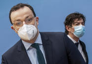 Jens Spahn, left, Federal Minister of Health, and Christian Drosten, Director of the Institute of Virology, Charité Berlin, arrive for a press conference on the current situation in the Corona pandemic in Berlin, Germany, Friday, Jan.22, 2021. (Michael Kappeler/dpa Pool via AP)