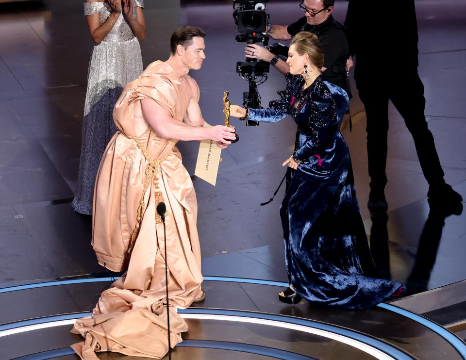 Holly Waddington accepts the Best Costume Design award for "Poor Things" from John Cena at the 96th Annual Oscars held at Dolby Theatre on March 10, 2024 in Los Angeles, California. (Photo by Rich Polk/Variety via Getty Images)