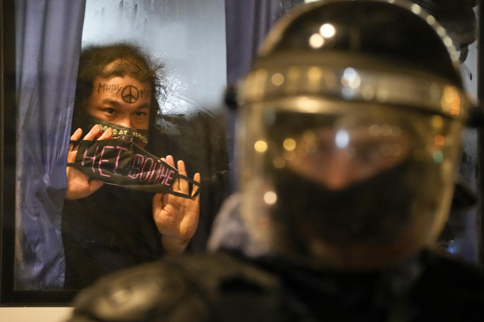 FILE - A detained demonstrator shows a sign 'No War!' from a police bus in St. Petersburg, Russia, Feb. 24, 2022. (AP Photo, File)