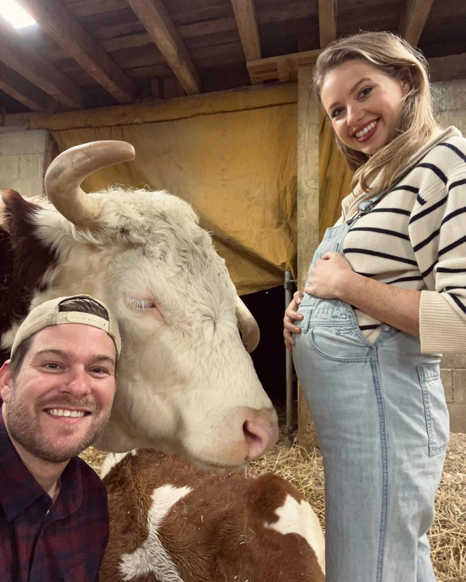 Dan McKernan, a cow and Kassandra Clementi in a barn