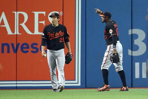 Hyun Soo Kim (left) and Adam Jones react to a fan throwing a beer can on the field. (Getty Images)