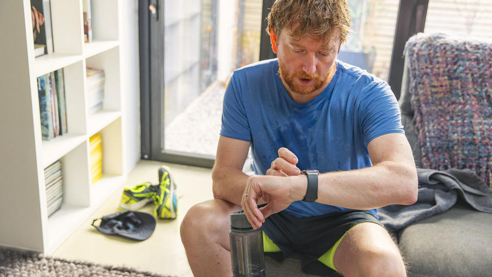 Man sitting down after a workout, looking sweaty