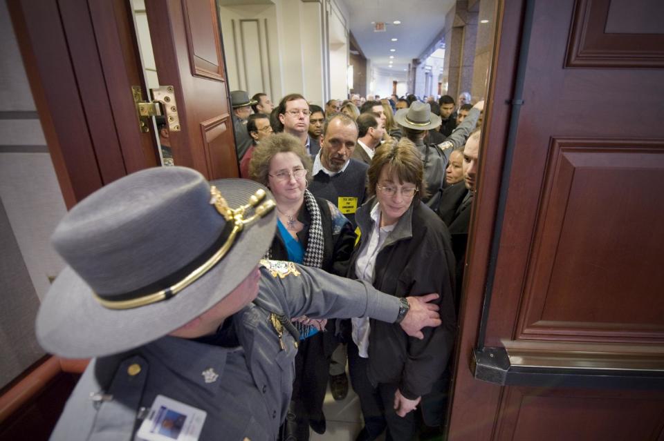 State Capitol Police handle a crowd spilling into a hallway after the room reaches the capacity for public hearing retail alcohol sales on Sundays at the Legislative Office Building in Hartford, Conn., Tuesday, Feb. 28, 2012. (AP Photo/Jessica Hill)