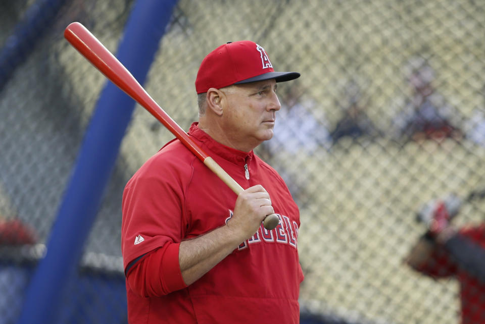 Los Angeles Angels manager Mike Scioscia pauses while hitting grounders before the Angels' exhibition baseball game against the Los Angeles Dodgers in Los Angeles, Friday, March 28, 2014. (AP Photo/Danny Moloshok)