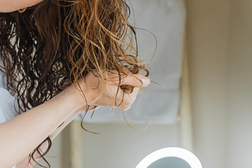 Woman scrunching product in curls to prepare it for hair plopping.