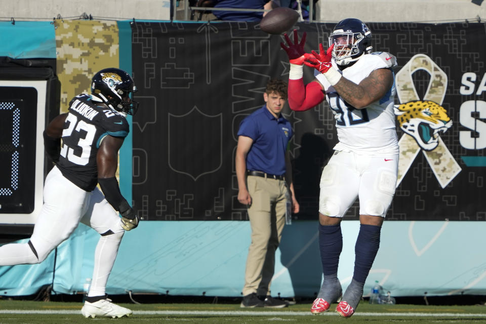 Tennessee Titans defensive tackle Jeffery Simmons, right, catches a touchdown pass as Jacksonville Jaguars linebacker Foyesade Oluokun (23) defends during the second half of an NFL football game, Sunday, Nov. 19, 2023, in Jacksonville, Fla. (AP Photo/John Raoux)