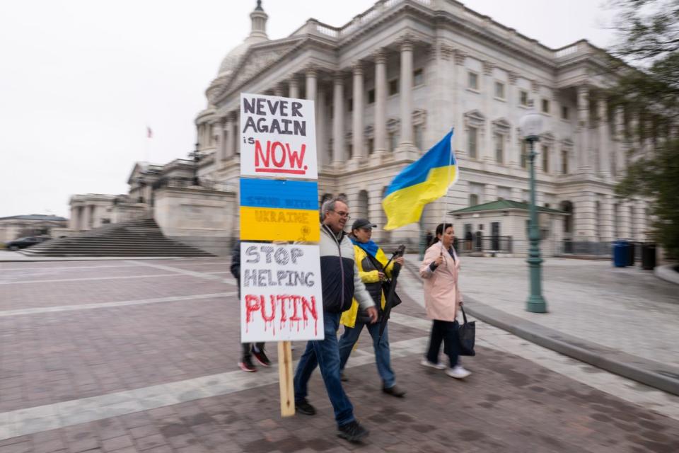 Ukraine sympathizers carry placards and fly a Ukrainian flag outside the U.S. Capitol building as the Senate works through the weekend on a $95.3 billion foreign aid bill with assistance for Ukraine and Israel in Washington, DC on Feb. 11, 2024. (Roberto Schmidt/Getty Images)