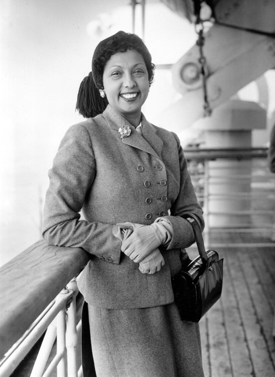 Josephine Baker leans against the railing of an ocean liner