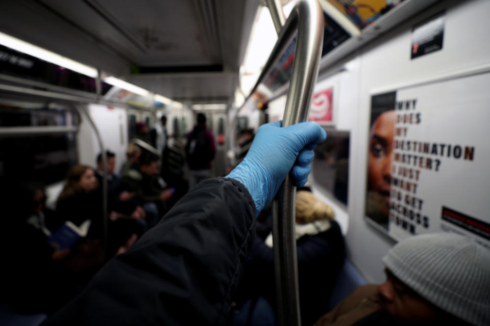 A man wears surgical gloves to prevent Covid-19 spread, at the New York City subway train in New York.