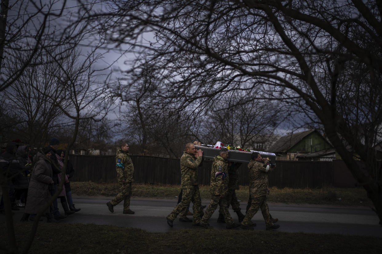 Ukrainian soldiers carry the body of Kostiantyn, 35, during his funeral in Borova, near Kyiv, Ukraine, Saturday, Feb. 18, 2023. Kostiantyn Kostiuk, a civilian who was a volunteer in the armed forces of Ukraine, was wounded during a battle against Russians on Jan. 23rd near Bakhmut and finally died on Feb. 10th in a hospital. (AP Photo/Emilio Morenatti)