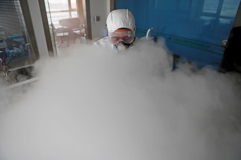 Worker with sanitizing equipment disinfects an office following an outbreak of the coronavirus in the country, in Shanghai