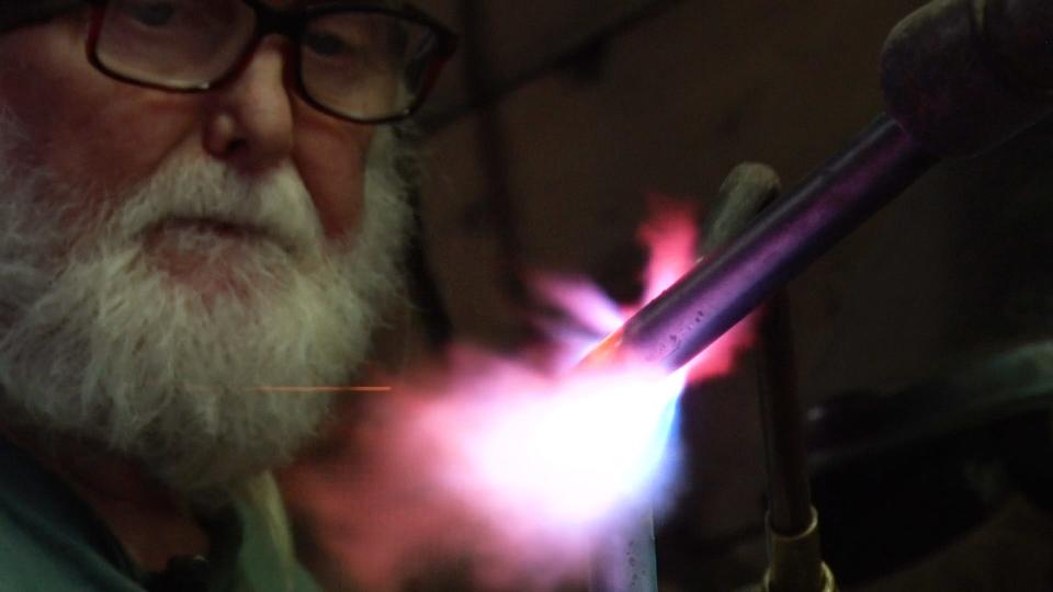 Blacksmith Michael Harrigan welds a rods of metal so it can be twisted into a new shape.