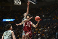 Oklahoma guard Milos Uzan (12) protects the ball from West Virginia forward James Okonkwo (32) and West Virginia forward Emmitt Matthews Jr., back, during the second half of an NCAA college basketball game in Morgantown, W.Va., Saturday, Feb. 4, 2023. (AP Photo/William Wotring)