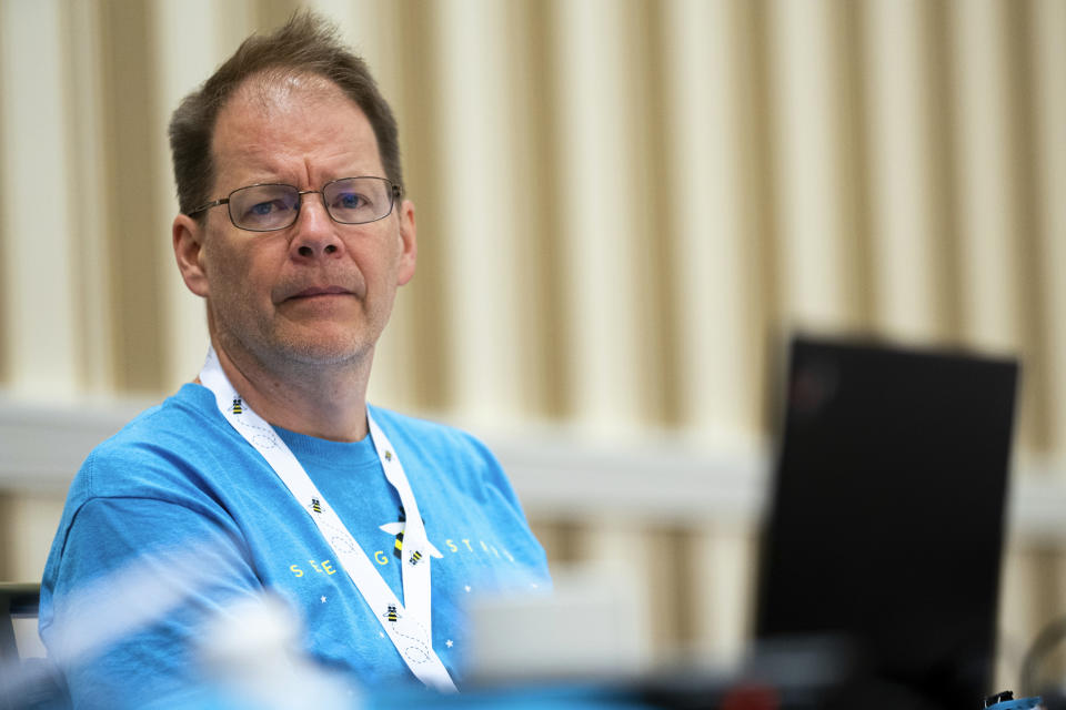 Pronouncer Jacques Bailly listens to a debate over proposed word definitions and sentence use during a meeting of the word panel to finalize the 2023 Scripps National Spelling Bee words on Sunday, May 28, 2023, at National Harbor in Oxon Hill, Md. (AP Photo/Nathan Howard)