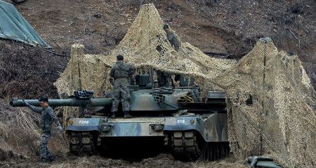 South Korean army soldiers set up a camouflage net over their tank during a military exercise near the demilitarized zone separating the two Koreas in Paju, South Korea, March 7, 2016. REUTERS/Hwang Ki-sun/News