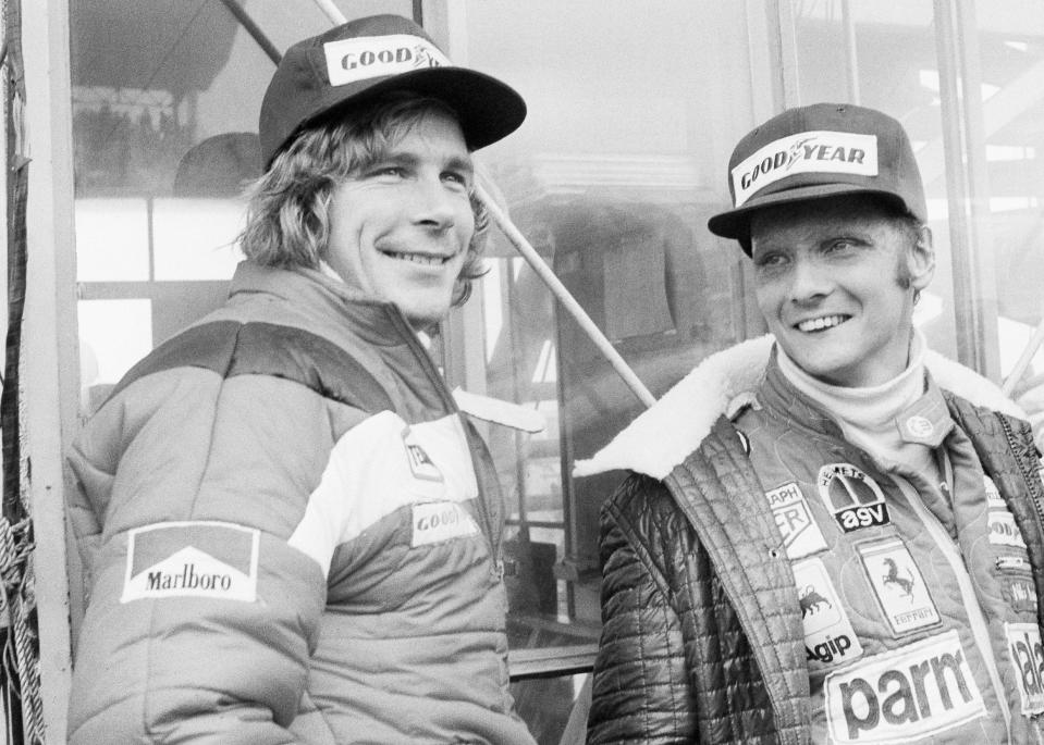 ARCHIVO - En esta foto de archivo del 24 de octubre de 1976, el piloto austríaco Niki Lauda (derecha) y el británico James Hunt sonríen antes del Gran Premio de Japón (AP Foto/Nick Ut, archivo)
