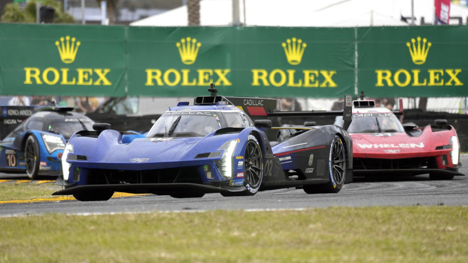 Earl Bamber, of New Zealand, center, in a Cadillac V-LMDh, leads Jack Aitken, of Great Britain, right, in a Cadillac V-LMDh and Filipe Albuquerque, of Portugal, left, in a Acura ARX-06 during the Rolex 24 hour auto race at Daytona International Speedway, Sunday, Jan. 29, 2023, in Daytona Beach, Fla. (AP Photo/John Raoux)