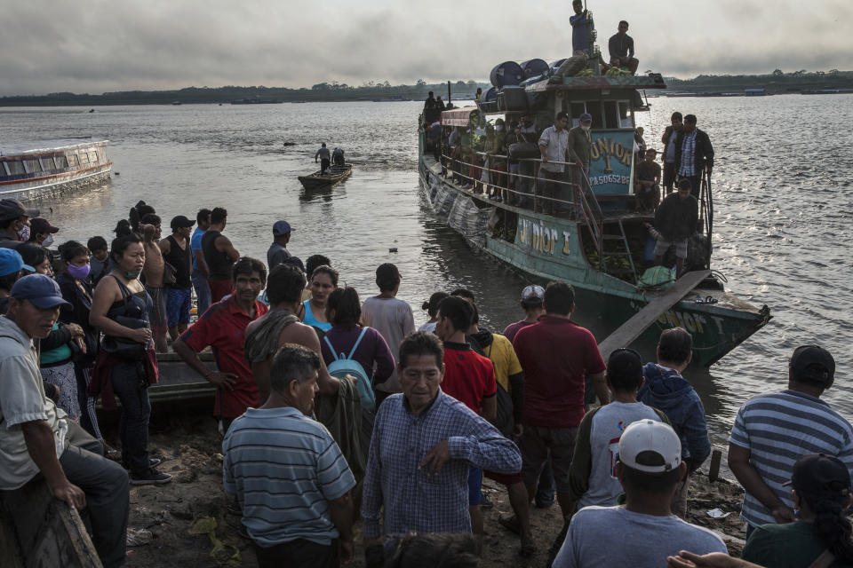 Pasajeros llegan en un barco-taxi público al puerto de la comunidad indígena shipibo de Pucallpa, junto al río Ucayali en la Amazonía peruana, en el este del país, el 3 de septiembre de 2020, en plena pandemia del coronavirus. El transporte es uno de los principales obstáculos a la hora de atender a las comunidades indígenas, ya que a algunas solo se puede acceder en helicóptero o tras un viaje de ocho horas en barco. (AP Foto/Rodrigo Abd)