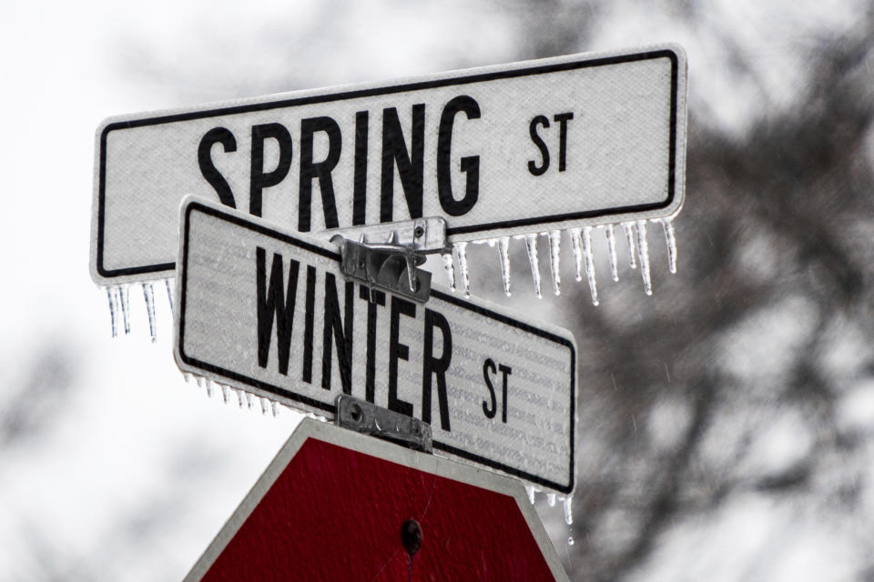 Freezing rain coats road signs for Winter and Spring streets in Spring Lake, Mich., on Monday, Feb. 27, 2023. (Cory Morse/MLive.com/The Grand Rapids Press via AP)