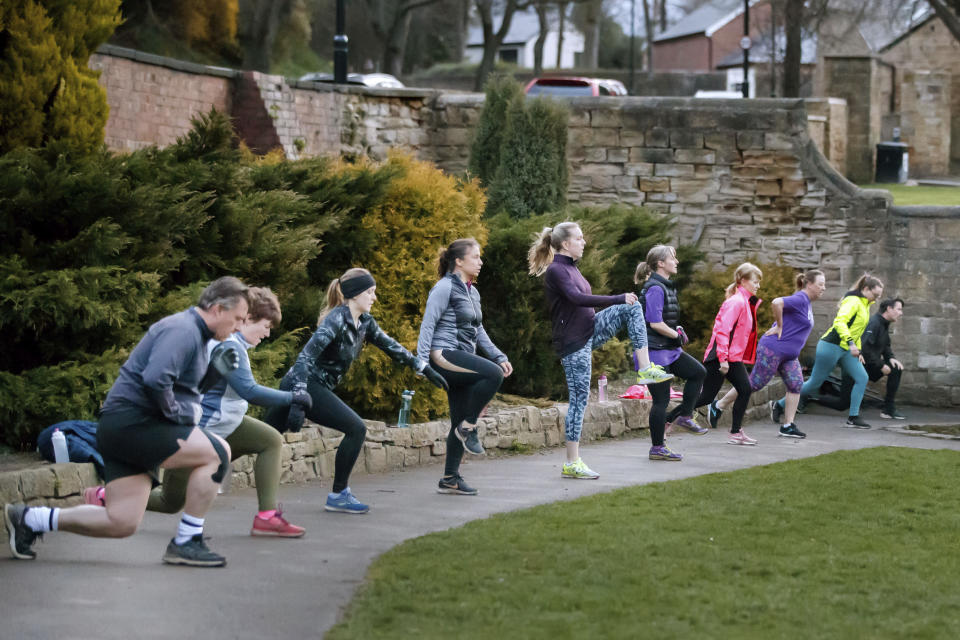 People take part in "Boot Camp" exercise class in Springhead Park, following the easing of England's lockdown to allow far greater freedom outdoors, in Rothwell, England, Monday March 29, 2021. England is embarking on a major easing of its latest coronavirus lockdown that came into force at the start of the year, with families and friends able to meet up in outdoor spaces and many sports permitted once again. Under Monday’s easing, groups of up to six, or two households, can socialize in parks and gardens once more, while outdoor sports facilities can reopen after the stark stay-at-home order, which has seen new coronavirus cases fall dramatically over the past three months, ended. (Danny Lawson/PA via AP)