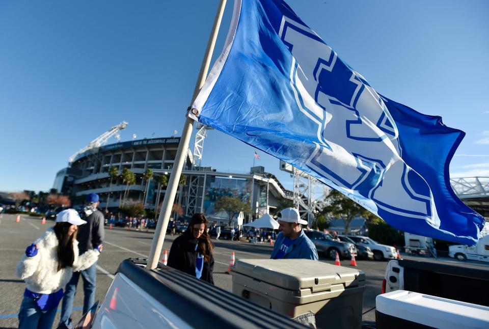 A UK flag flaps in the cool breeze as fans arrive at the parking lot outside EverBank Stadium ahead of Friday's Gator Bowl game. The Kentucky Wildcats faced off against the Clemson Tigers Friday, December 29, 2023, in the TaxSlayer Gator Bowl in Jacksonville, Florida. [Bob Self/Florida Times-Union]