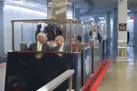 U.S. Senator Rob Portman (R-OH) (L) and Senator Lindsey Graham (R-SC) (R) arrive together on a subway car for votes on the Senate floor at the U.S. Capitol in Washington December 12, 2014. REUTERS/Jonathan Ernst
