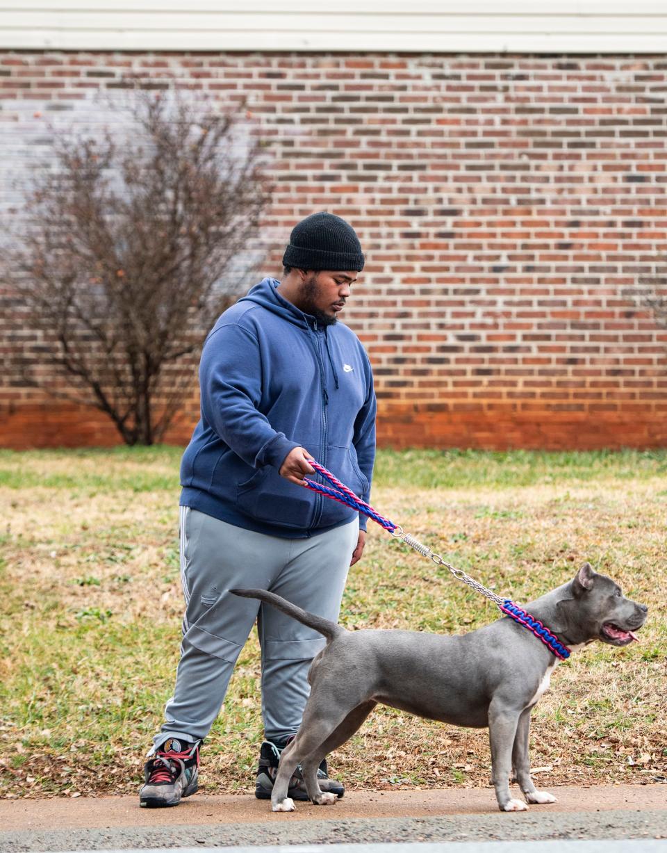 Kevin Allen, 18, of Greenville, stops to pose for a portrait on a walk with his dog in his neighborhood in Greenville, Friday, February 18, 2022.