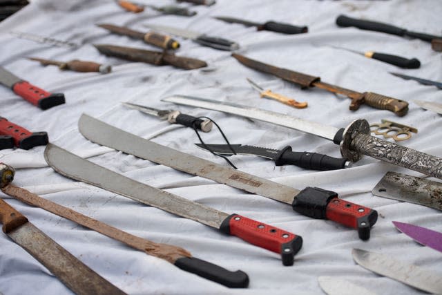 Various large knives laid out on a white sheet