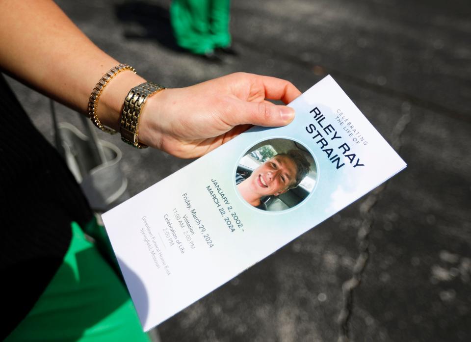 A mourner holds the program from Riley Strain's celebration of life at Greenlawn Funeral Home in Springfield, Mo. on Friday, March 29, 2024.