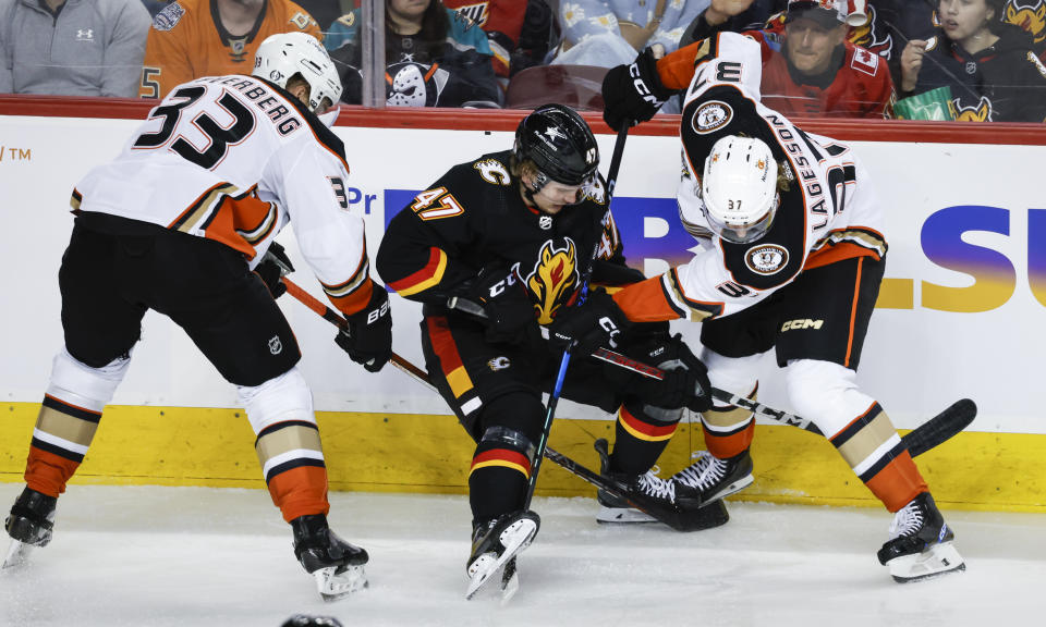 Anaheim Ducks forward Jakob Silfverberg (33) and defenseman William Lagesson (37) check Calgary Flames forward Connor Zary (47) during the second period of an NHL hockey game Tuesday, April 2, 2024, in Calgary, Alberta. (Jeff McIntosh/The Canadian Press via AP)