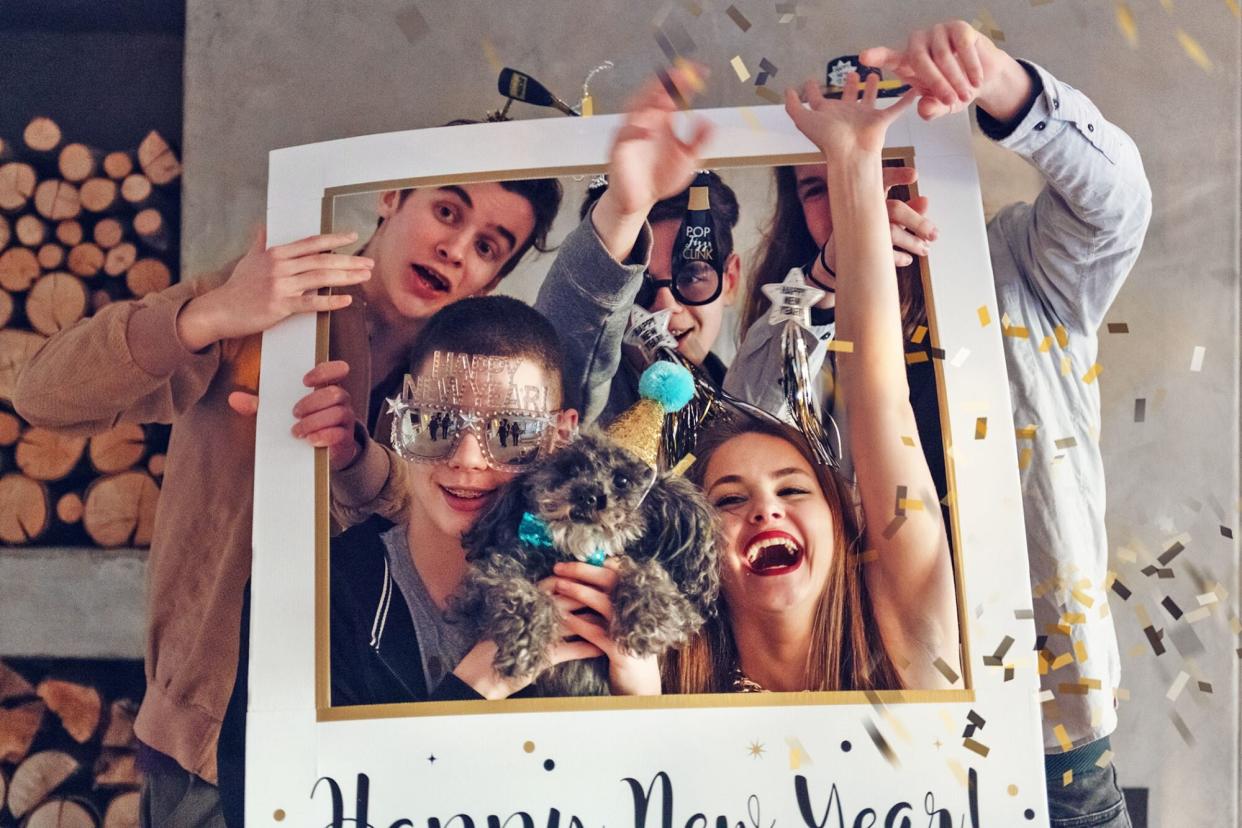 group of young adult with New Year's photo props and a dog