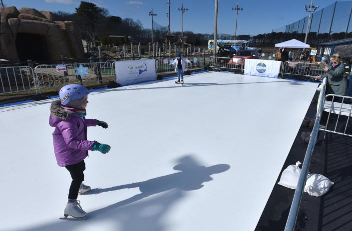 Eight-year-old Emma Baker glides around on a slick plastic &quot;ice rink&quot; on Feb. 18 with sister Ainsley, 9, as the Yarmouth Chamber of Commerce and the Yarmouth Recreation Department put on their Winter Carnival at Skull Island on Route 28 in South Yarmouth.