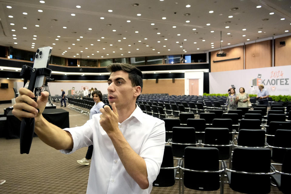 Popular YouTuber and TikToker with millions of online followers Fidias Panayiotou holds his cell phone after his proclamation as the winner of one of six seats allotted to Cyprus in the European Parliament at the Filoxenia Conference Center in the capital Nicosia, Cyprus, on Tuesday, June 11, 2024. The 24-year-old Cypriot says he will continue using social media in his new job as a member of the European Parliament because he sees it as "my biggest weapon to use" in affecting the kind of change he wants to see on issues such as education. (AP Photo/Petros Karadjias)
