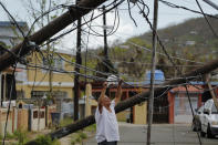 <p>A resident uses a plastic bag to move downed power cables so he can drive underneath them in a neighborhood following Hurricane Maria in Ceiba, Puerto Rico, Oct. 4, 2017. (Photo: Lucas Jackson/Reuters) </p>