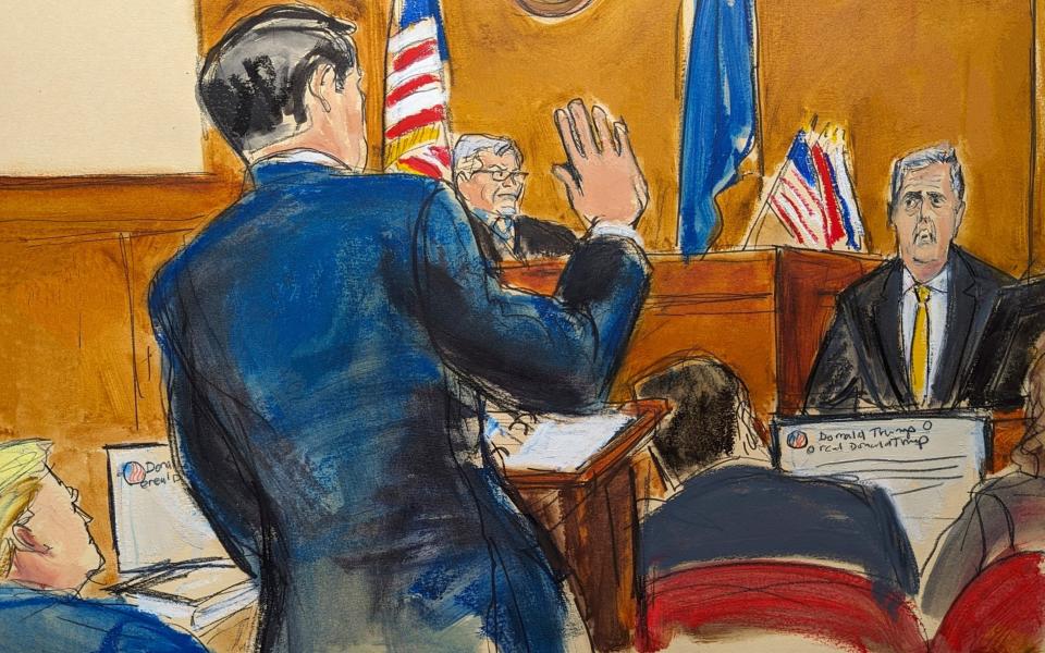 Defense attorney Todd Blanche stands making the "swearing in" hand gesture when cross-examining Michael Cohen, as Donald Trump, left, looks on