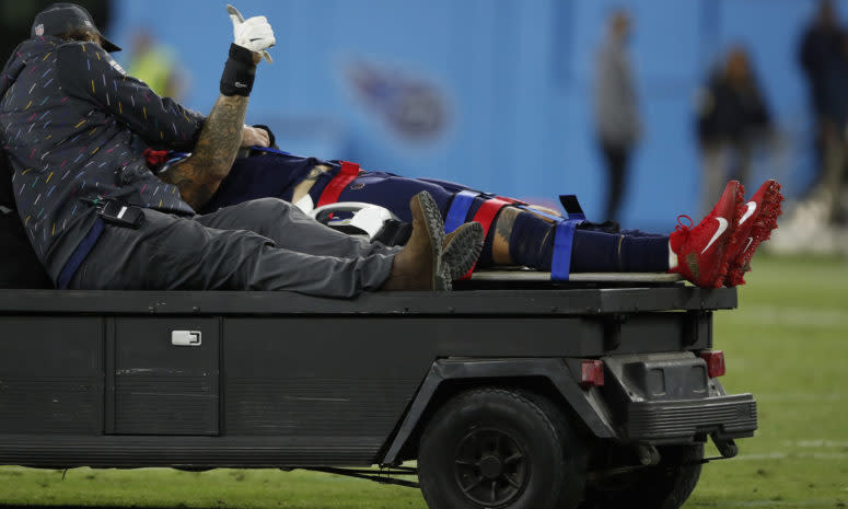 Tennessee Titans left tackle Taylor Lewan gives a thumbs up as he's carted off the field with a head injury.