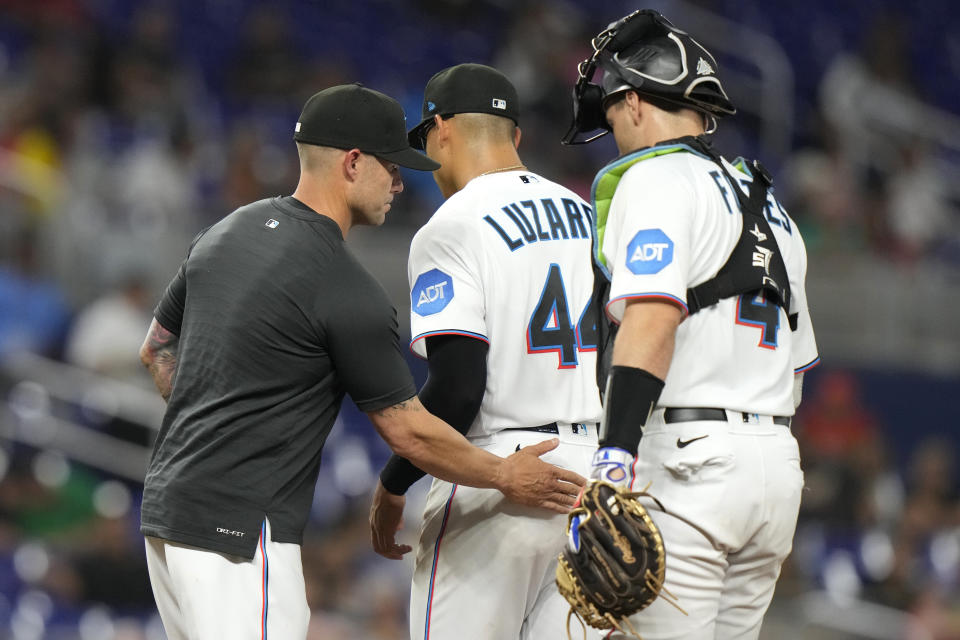 Miami Marlins starting pitcher Jesus Luzardo (44) walks from the mound as manager Skip Schumaker, left, makes a pitching change during the fifth inning of a baseball game against the San Francisco Giants, Monday, April 17, 2023, in Miami. (AP Photo/Lynne Sladky)