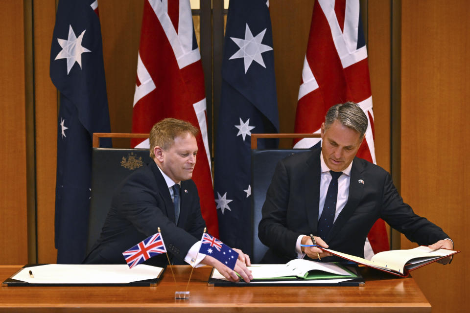 Secretary of State for Defence of the United Kingdom Grant Shapps, left, and Australian Defence Minister Richard Marles sign a new defence and security cooperation agreement at Parliament House at Parliament House in Canberra, Thursday, March 21, 2024. (Lukas Coch/AAP Image via AP)