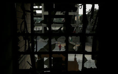 A Palestinian man looks at the Ministry of Religious Affairs that was damaged by Israeli air strikes in Gaza City July 15, 2018. REUTERS/Suhaib Salem