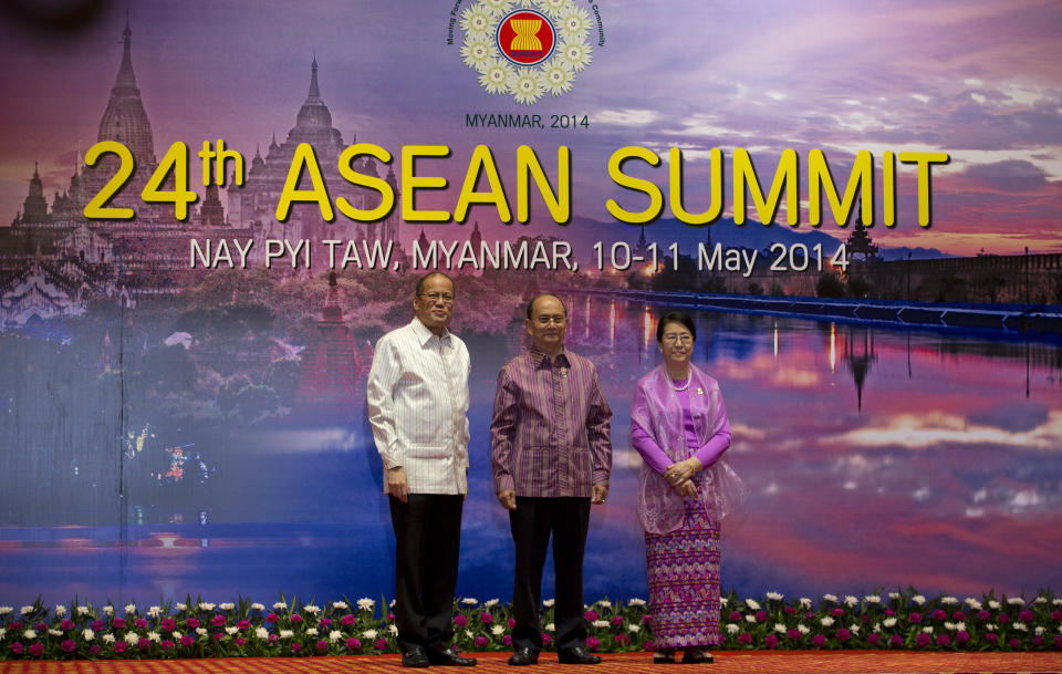 Myanmar President Thein Sein, center, and his wife Khin Khin Win, right, pose for a picture with Philippines President Benigno "Noynoy" Aquino III, ahead of the dinner hosted by Thein Sein during 24th Association of Southeast Asian Nations Summit in Naypyitaw, Myanmar, Saturday, May 10 2014. (AP Photo/Gemunu Amarasinghe)