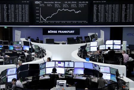 Traders work at their desks in front of the German share price index, DAX board, at the stock exchange in Frankfurt, Germany, February 18, 2016. REUTERS/Staff/Remote