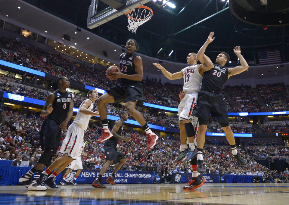 San Diego State forward Josh Davis (22) pulls down a rebound as Arizona guard Nick Johnson (13), San Diego State forward JJ O'Brien (20) and Skylar Spencer (0) watch during the first half in a regional semifinal of the NCAA men's college basketball tournament, Thursday, March 27, 2014, in Anaheim, Calif. (AP Photo/Mark J. Terrill)